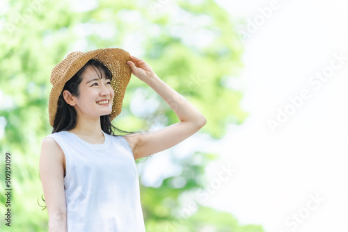 夏に麦わら帽子を被る女性（笑顔・紫外線対策） 