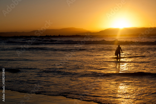 Obraz na płótnie sunset with a lone surfer in byron bay australia
