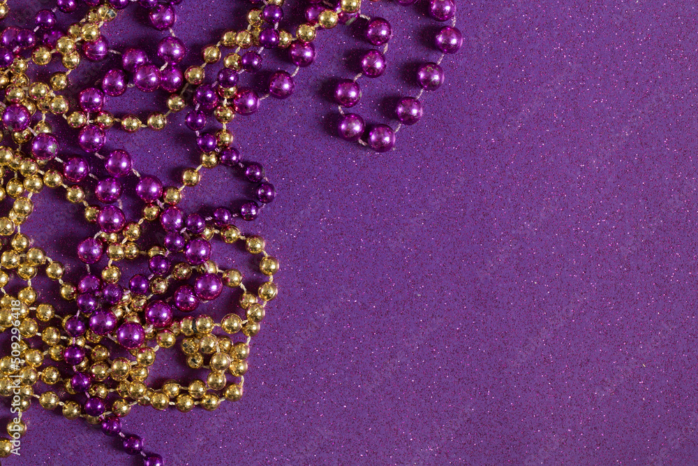 Mardi Gras Beads on a Purple Glitter Background Mardi Gras Beads on a Purple Glitter Background
