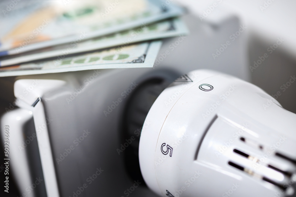 Increase in the cost of bill for gas and electricity concept. Radiator with banknotes close-up Increase in the cost of bill for gas and electricity concept. Radiator with banknotes close-up