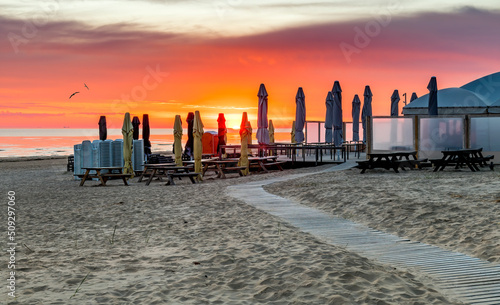 Colorful sunrise on sandy beach of the Baltic Sea photo