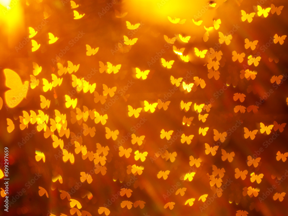abstract yellow butterfly shape bokeh on golden red blurred light background.