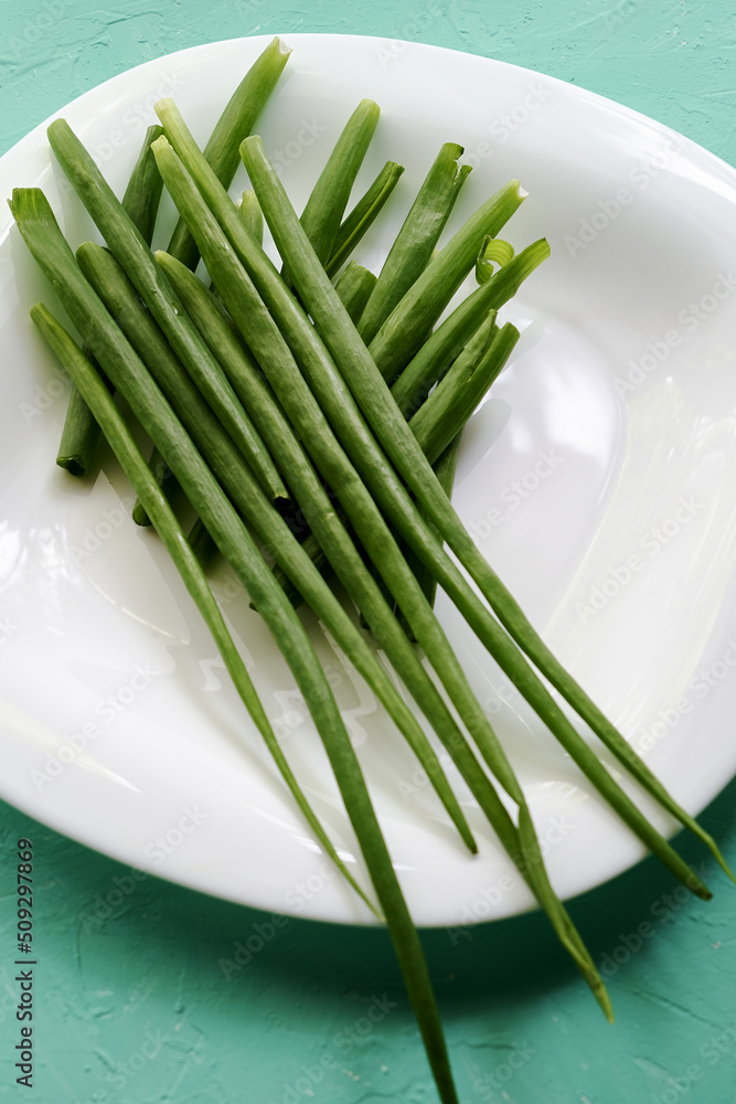 green onion leaves on a white plate on the table green onion leaves on a white plate on the table