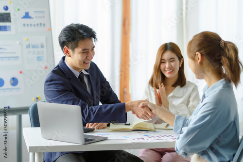 Wallpaper Mural Happy young Asian business people shaking hands to congratulate success. Business executives handshake to congratulate the joint business agreement. Torontodigital.ca