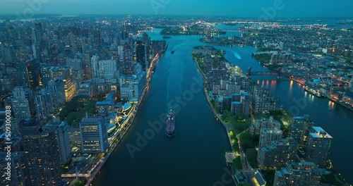 Boats moving by the calm river in beautiful New York. Evening time with lights on in fantastic metropolis. Top view.