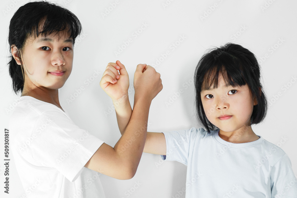 Portrait of two beautiful Asian girls expressing a loving greeting with smiling faces on plaster. Portrait of two beautiful Asian girls expressing a loving greeting with smiling faces on plaster.