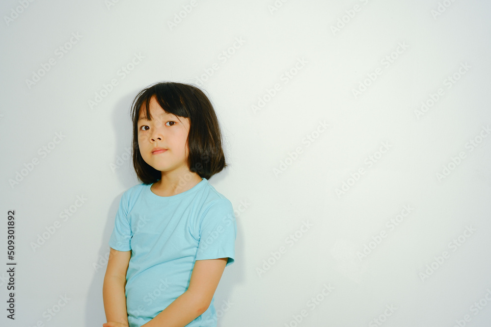 Photo background of an Asian girl wearing a blue shirt on white plaster. Photo background of an Asian girl wearing a blue shirt on white plaster.