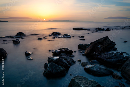 Long exposure photo of sea  rocks and sunset. Concept of relax  calm  tranquil and inner peace.