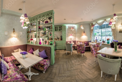 Obraz na plátně Cozy cafe interior with soft sofas and chairs, shelves with romantic trinkets, l
