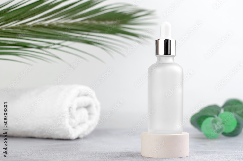 Cosmetic bottle with essential oil or serum on a light background. Skin care and beauty concept Cosmetic bottle with essential oil or serum on a light background. Skin care and beauty concept
