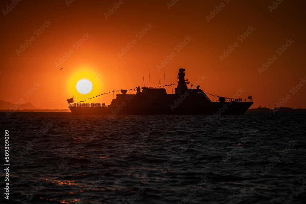 Izmir. Silhouette of a warship on the background of the sunset over the Aegean Sea Izmir. Silhouette of a warship on the background of the sunset over the Aegean Sea
