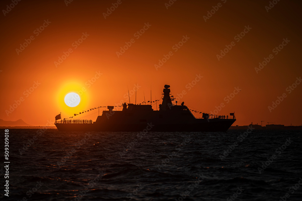 Izmir. Silhouette of a warship on the background of the sunset over the Aegean Sea Izmir. Silhouette of a warship on the background of the sunset over the Aegean Sea