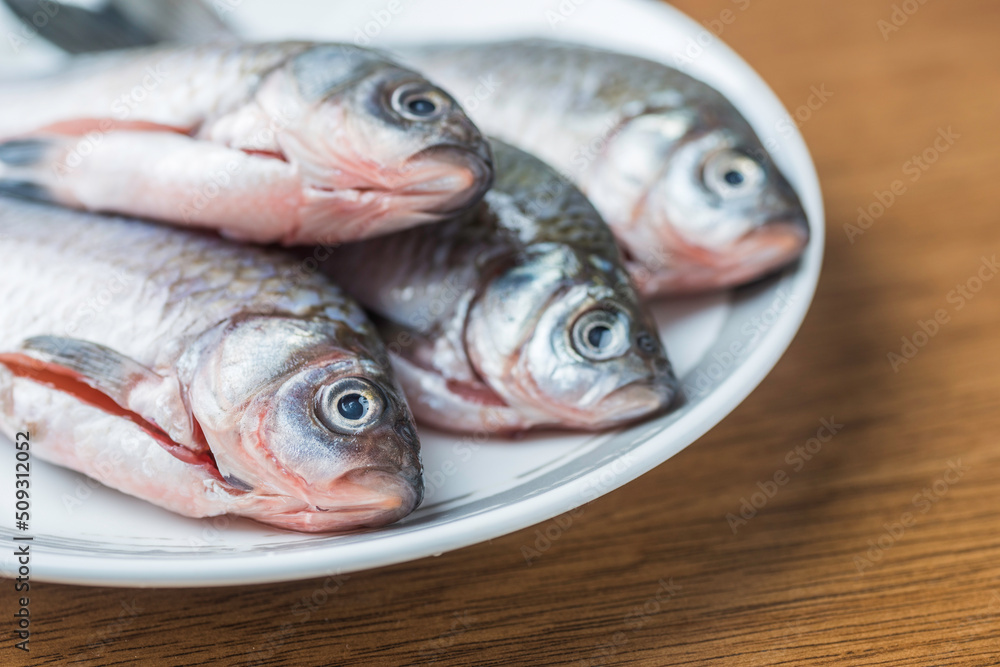 White porcelain dish four clean wild crucian carps on the plate White porcelain dish four clean wild crucian carps on the plate
