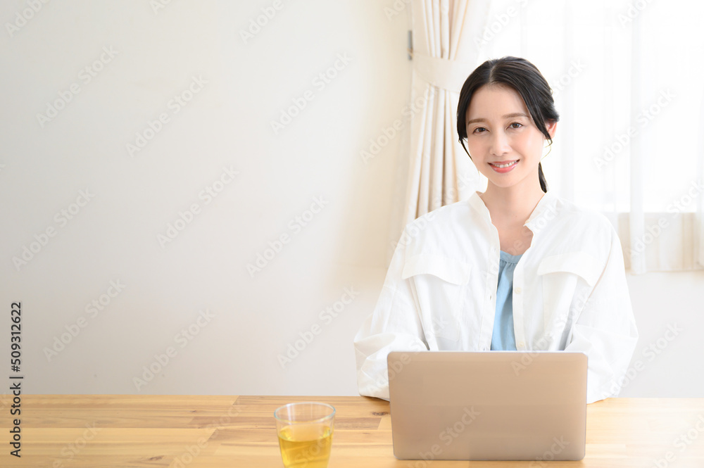 パソコンの仕事をする美しい女性　左にコピースペースあり