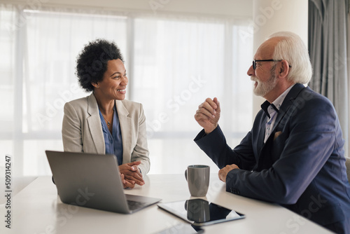 Smiling business professionals planning strategy in meeting at office desk