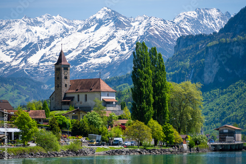 Obraz na plátne church with snowy alps over Brienz lake in Switzerland