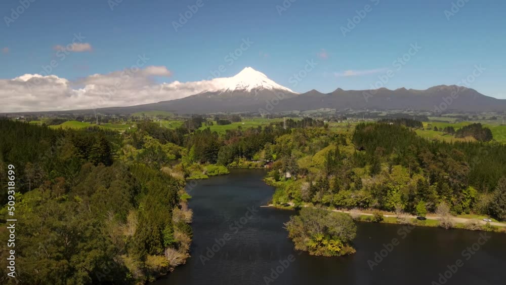 Natural wonder of Taranaki volcano and amazing New Zealand landscape with lake and native forest - drone pull back Natural wonder of Taranaki volcano and amazing New Zealand landscape with lake and native forest - drone pull back