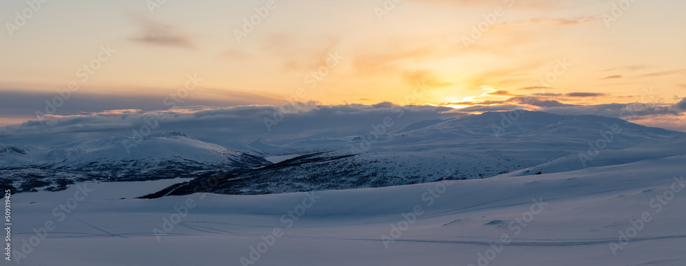 Panoramic sunset, golden light over Norwegian snowy winter mountains. Joesjo, Sweden