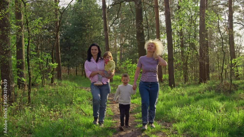 Family on a walk in the park. Grandmother mom and kids boy and girl walking on the path in nature walking, happy family spending time together, different generations. Family on a walk in the park. Grandmother mom and kids boy and girl walking on the path in nature walking, happy family spending time together, different generations.