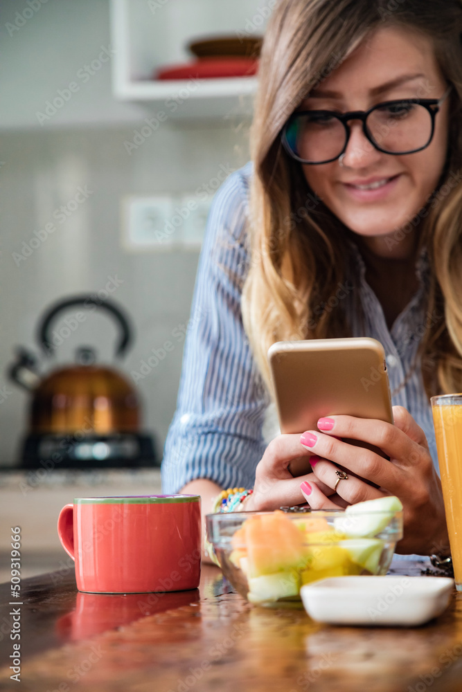 Young adult woman using smartphone in a modern home. Young adult woman using smartphone in a modern home.