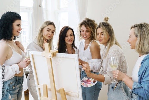 Photography Group of women paint on canvas and drinking white wine during party at home
