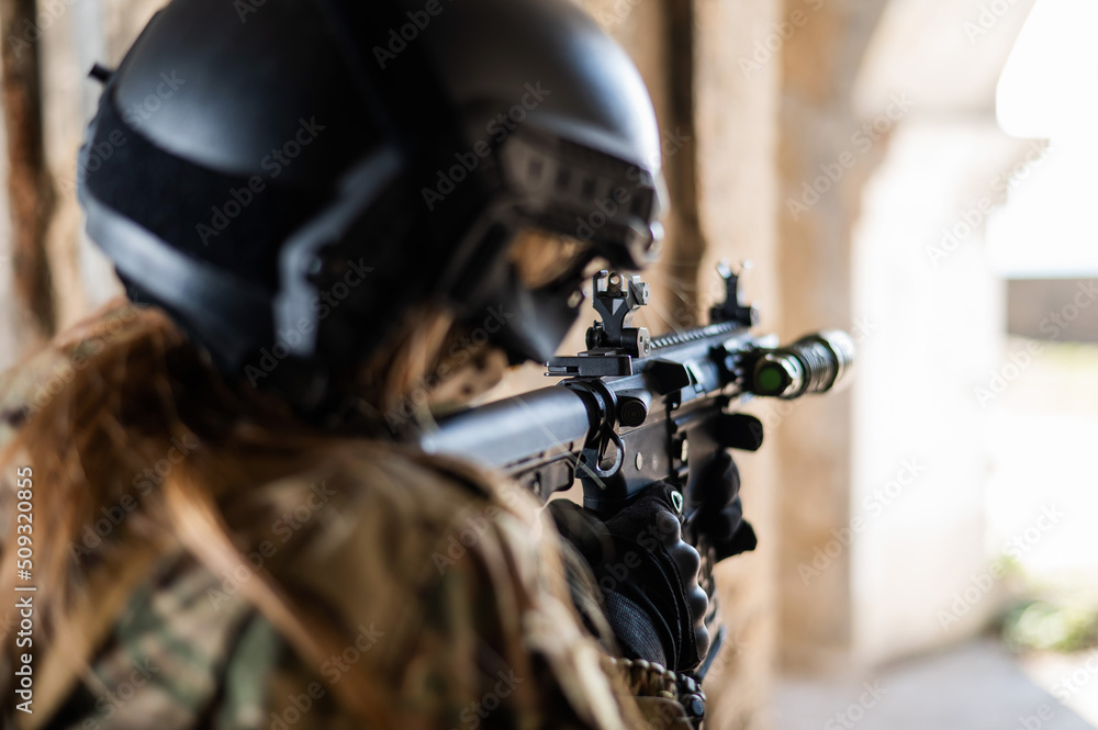 A woman in an army uniform shoots a firearm in an abandoned building. A woman in an army uniform shoots a firearm in an abandoned building.