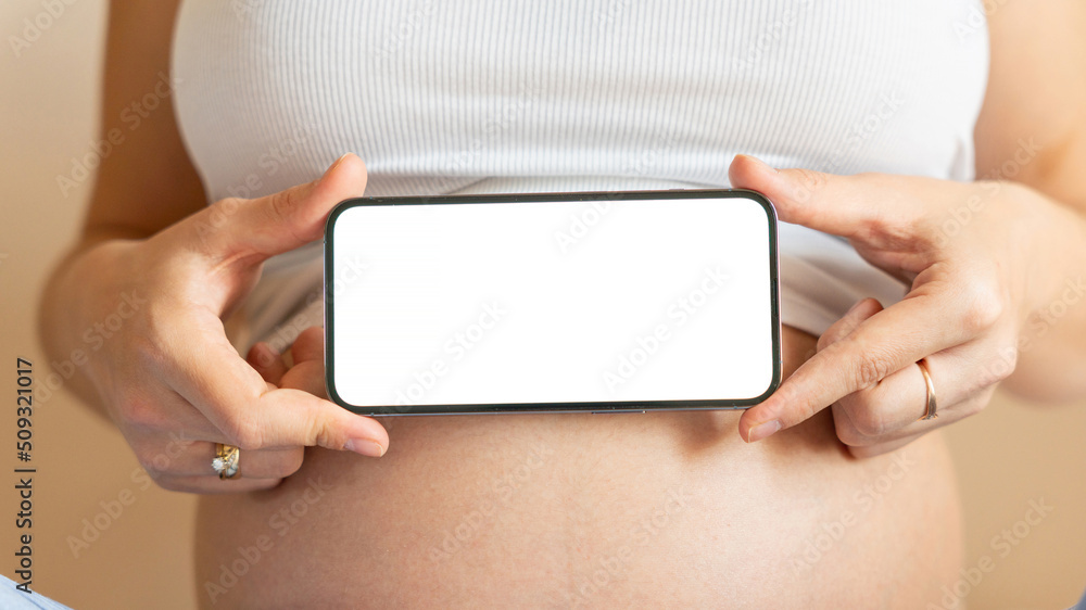 Pregnancy mockup display. Pregnant woman holding smartphone. Mobile pregnancy online maternity application mock up. Concept maternity, pregnancy, childbirth.