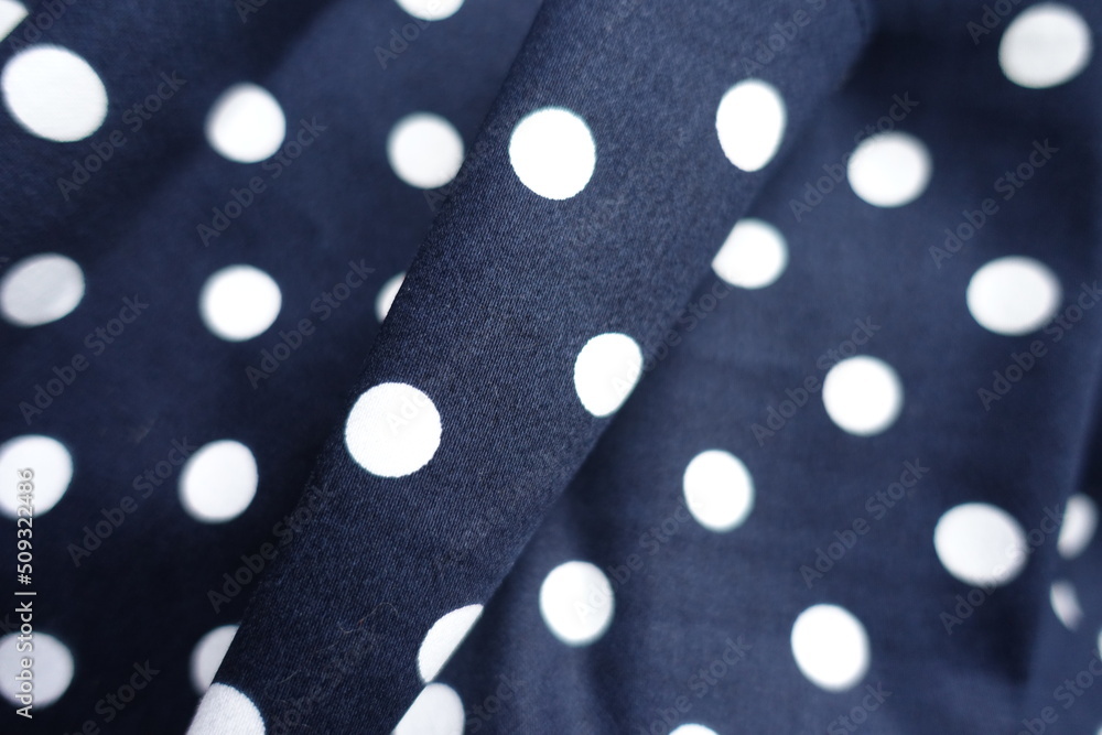 dark blue and white cotton fabric with polka dot pattern in soft folds dark blue and white cotton fabric with polka dot pattern in soft folds