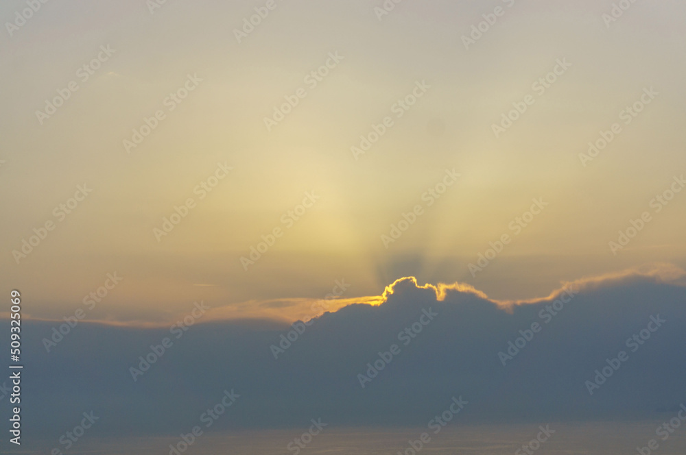 Naklejka premium Evening sunset with sun rays through the clouds over the sea