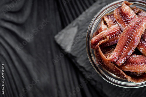 canned anchovy fillet on a black wooden rustic background