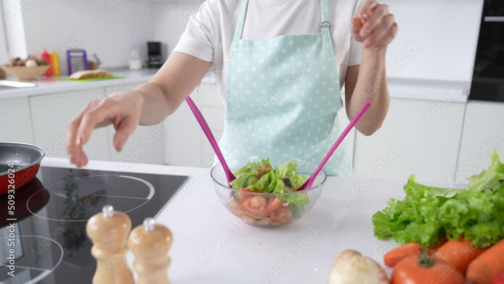 Professional chef adding herbal variety flavors into ready green salad Professional chef adding herbal variety flavors into ready green salad