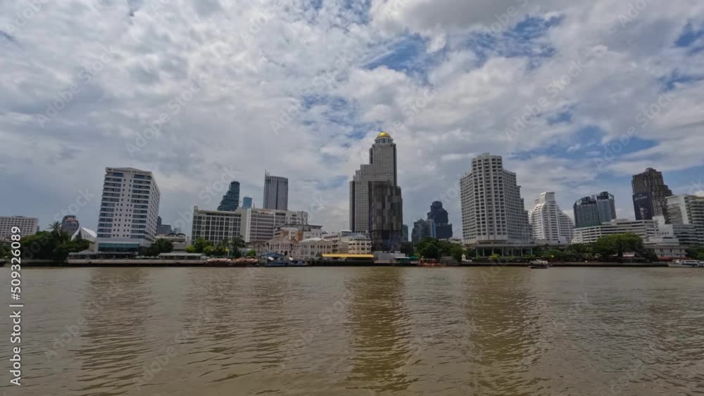 Bangkok Downtown Skyline with Boats Moving on Chao Phraya River, Thailand. Clouds floating over buildings time lapse Bangkok Downtown Skyline with Boats Moving on Chao Phraya River, Thailand. Clouds floating over buildings time lapse