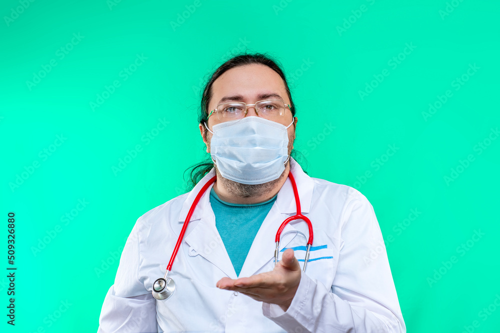 A doctor in a white coat and mask holds an empty open palm in front of him. Mockup template with blank space for a medical item. A doctor in a white coat and mask holds an empty open palm in front of him. Mockup template with blank space for a medical item.