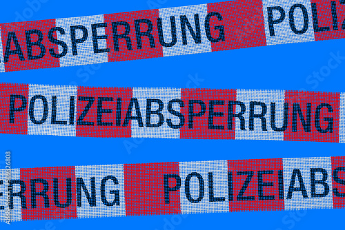 Barrier tapes with the inscription POLICE CORDON in German isolated on a blue background. © Николай Батаев