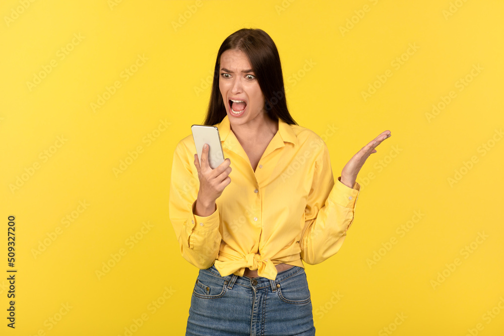 Angry Lady Shouting Holding Smartphone Reading Message On Yellow Background Angry Lady Shouting Holding Smartphone Reading Message On Yellow Background