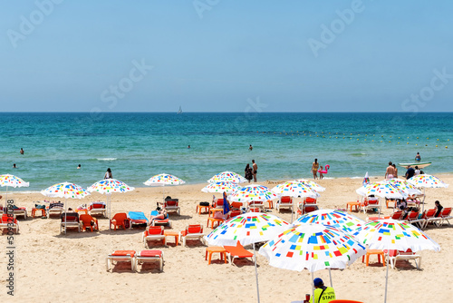 Public beach scene in summer. Summer travel location.