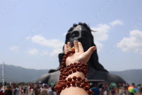 The Worship scene with the hands of a woman surrounded by Rudraksha in front of Lord Adiyogi Shiva. photo