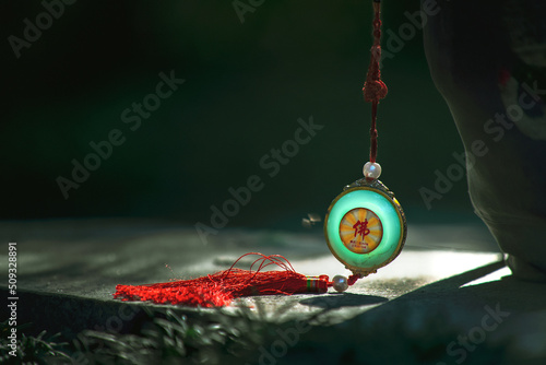A Buddha in your heart, everything is the Buddha. A jade pendant with fringes on it photo