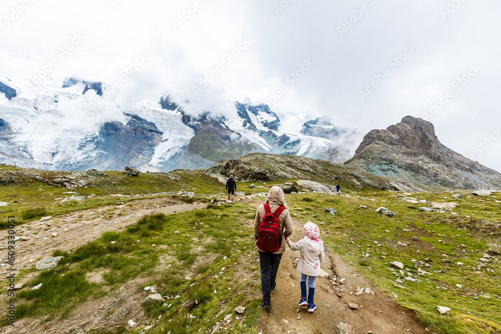 Mother and to children going for a walk in mountain surroundings
