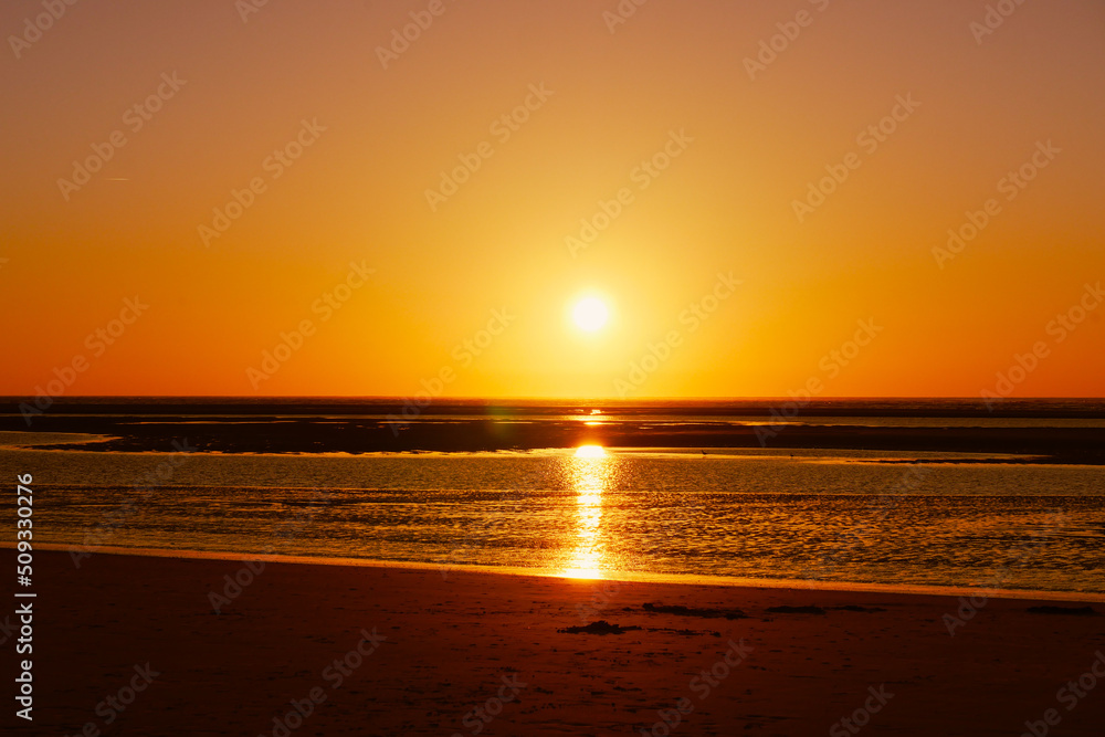 Golden sky and sunset over sea and horizon.