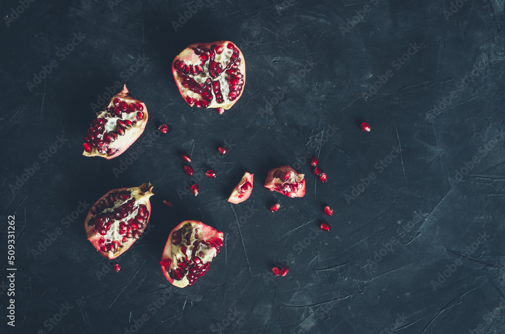 Fototapeta premium Red juicy pomegranate on dark background. Copy space.