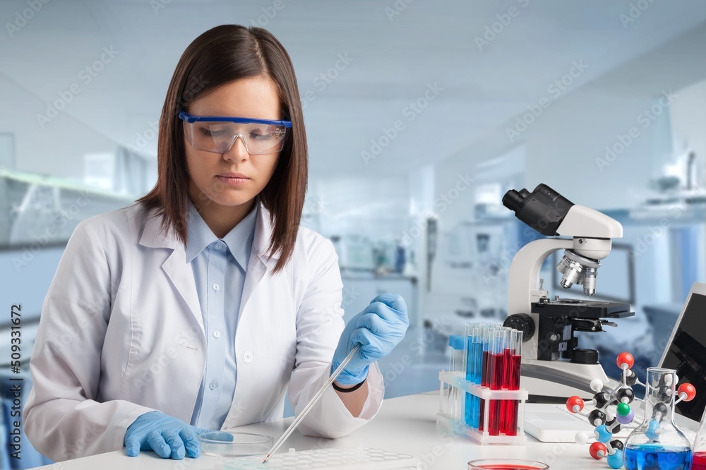 Woman scientist working in lab. Research concept. Microscope at blood and chemical test sample Woman scientist working in lab. Research concept. Microscope at blood and chemical test sample