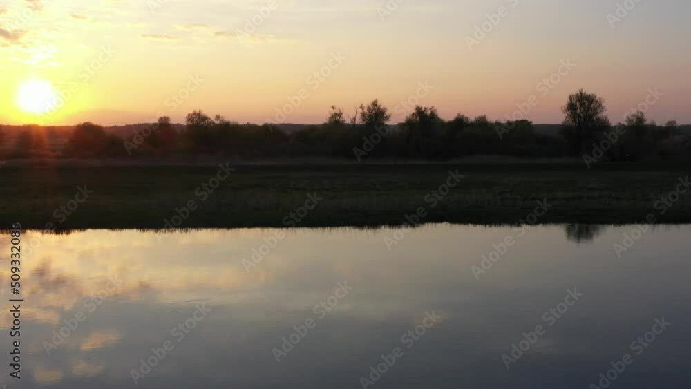 Tracking shot along Odra river during cloudy sunset over countryside, Poland Tracking shot along Odra river during cloudy sunset over countryside, Poland