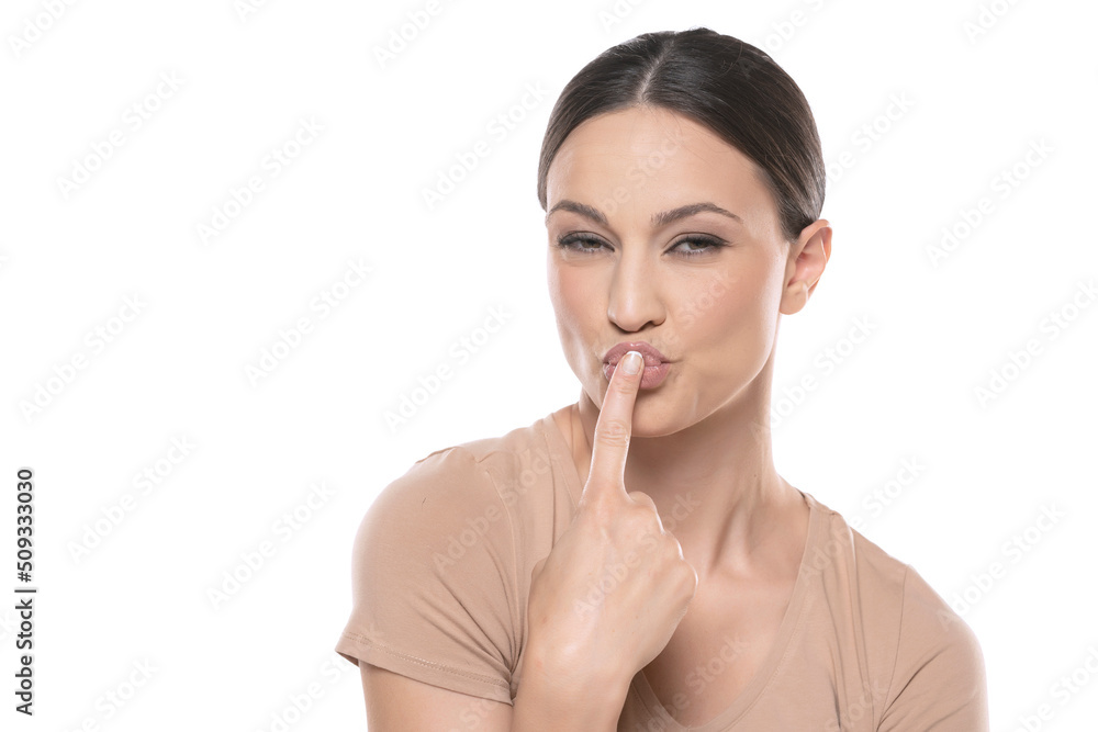 portrait of handsome young woman kissing her finger over white background portrait of handsome young woman kissing her finger over white background