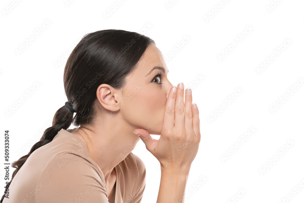 Profile image of whispering young lady , posing isolated over white background Profile image of whispering young lady , posing isolated over white background
