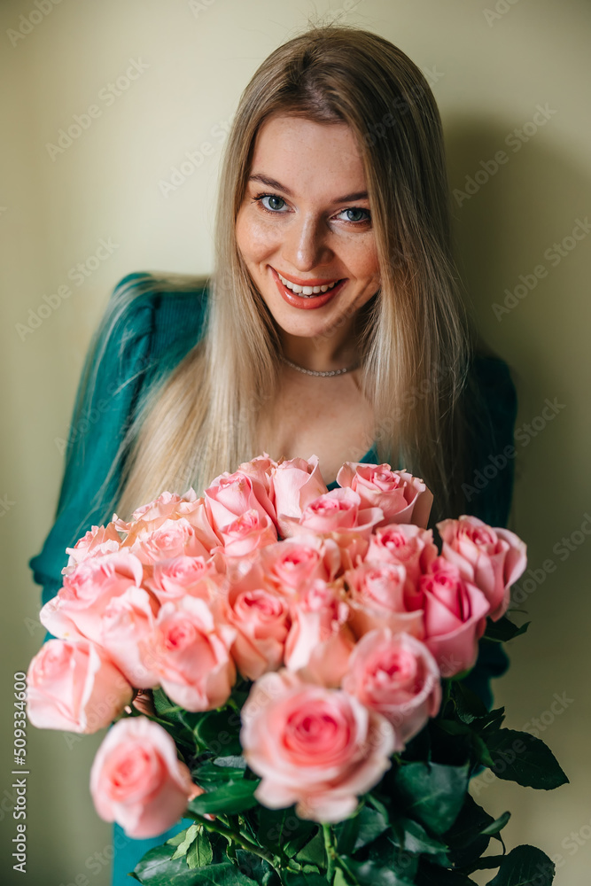 A woman in a dress holds a beautiful bouquet with flowers on a light background. Surprise for Valentine's Day, birthday A woman in a dress holds a beautiful bouquet with flowers on a light background. Surprise for Valentine's Day, birthday
