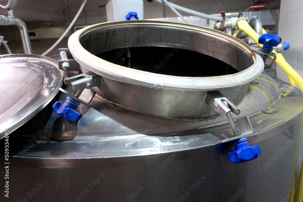 Промышленный интерьер современной пивоварни с хромированными цилиндрическими металлическими пивными баками. Частная микропивоварня.
