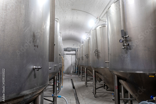 Промышленный интерьер современной пивоварни с хромированными цилиндрическими металлическими пивными баками. Частная микропивоварня. 