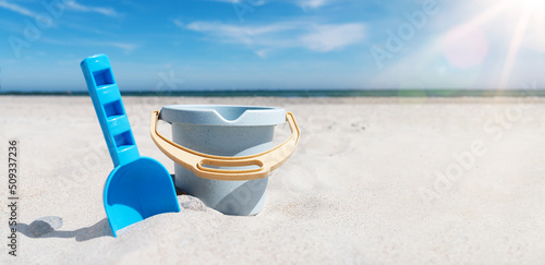 Billede på lærred close-up view of toy bucket and spade on sand beach against sea and blue sky
