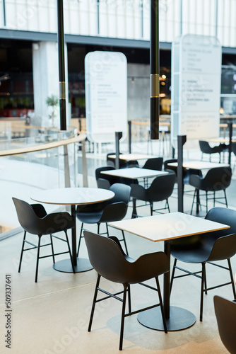 Minimal background image of minimal food court interior in black and white with tables and chairs in row, copy space